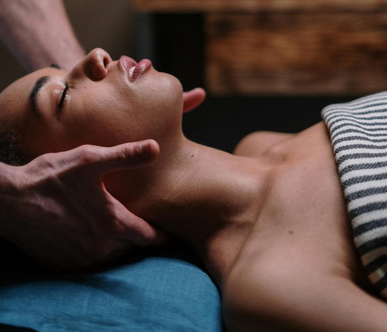 A woman enjoying a relaxing face massage in a tranquil spa setting.