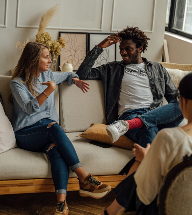 Two people enjoying a relaxed conversation in a modern living room setting.